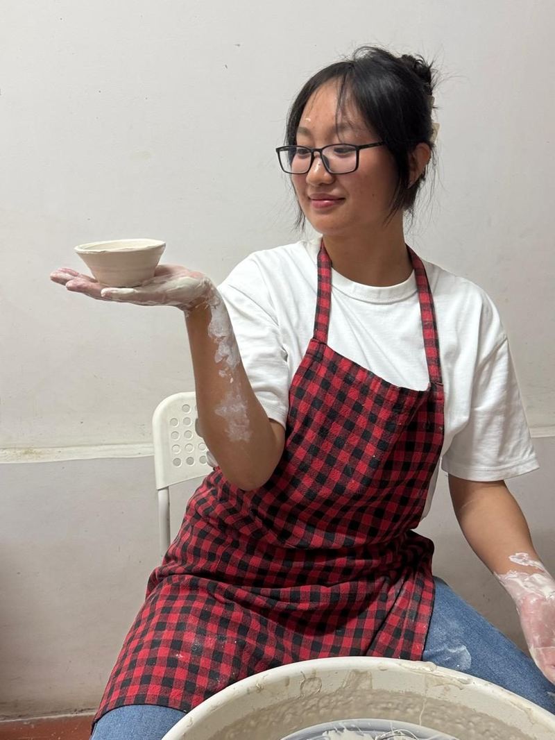 Student holding finished bowl at Mudcast